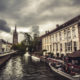 Bridges of Bruges :  Dijver canal tour boats and Our Lady cathedral - static time lapse