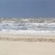 Kite, sand blown and beach empty : windy day on the Belgian Coast - static real time