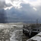 Belgian sea landscape : clouds, lighthouse, waves and wooden pier - static real time